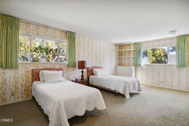 bedroom featuring a textured ceiling, wallpapered walls, baseboards, and carpet floors