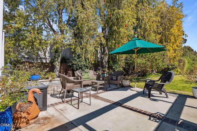 view of patio with an outdoor living space and fence