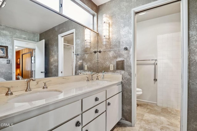 full bathroom featuring a sink, toilet, walk in shower, and double vanity