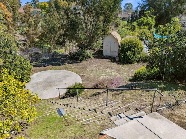 view of yard with a storage shed, an outdoor structure, and fence