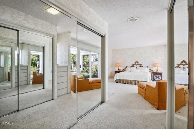 bedroom with wallpapered walls, carpet floors, and a textured ceiling