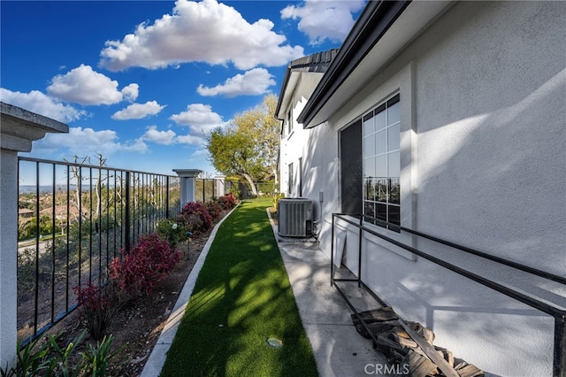 view of yard featuring central AC unit and fence