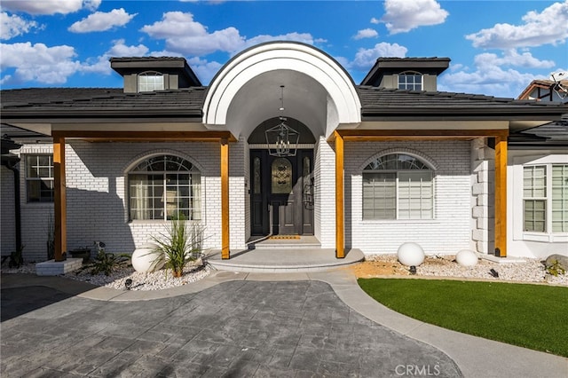 doorway to property with brick siding