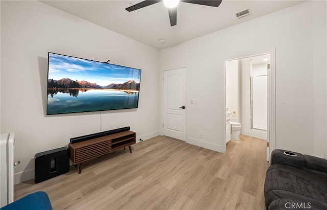 sitting room with light wood-style flooring, a ceiling fan, visible vents, and baseboards