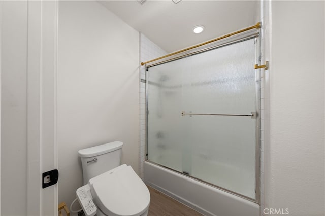 full bathroom with toilet and shower / bath combination with glass door