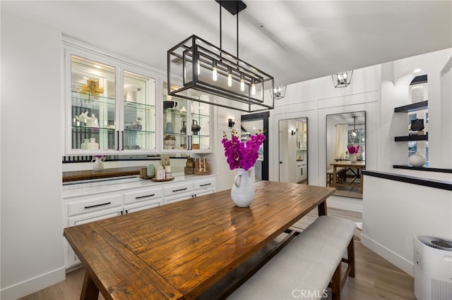 dining area with baseboards, a notable chandelier, and wood finished floors