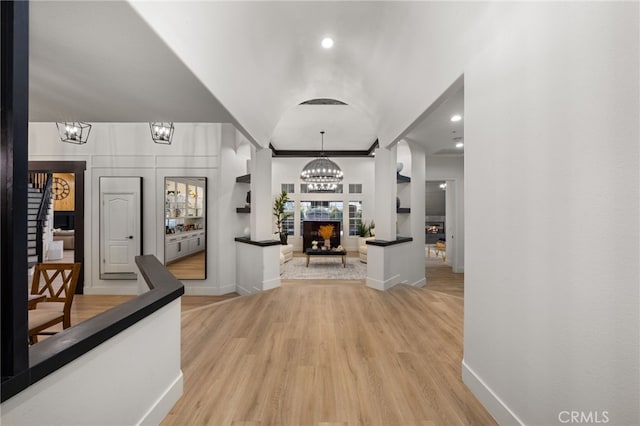 corridor featuring recessed lighting, baseboards, light wood finished floors, and a chandelier