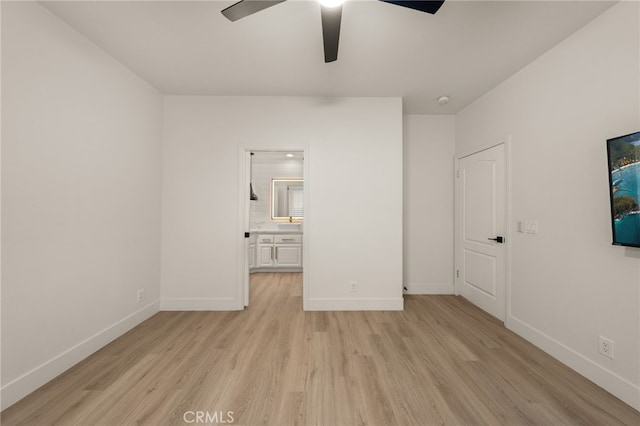 unfurnished bedroom with a ceiling fan, ensuite bath, baseboards, and light wood-type flooring