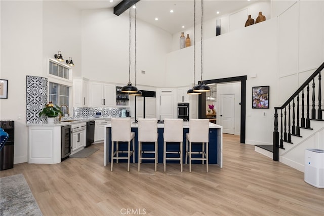 kitchen with beamed ceiling, pendant lighting, light countertops, black dishwasher, and paneled fridge