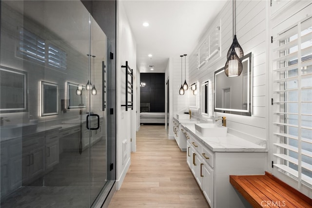 full bath with recessed lighting, a stall shower, vanity, and wood finished floors