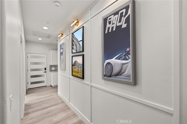 hall featuring recessed lighting, visible vents, light wood-style floors, and attic access