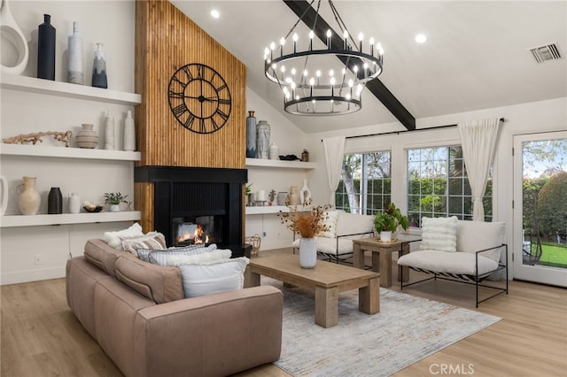 living area with wood finished floors, a healthy amount of sunlight, visible vents, and a large fireplace