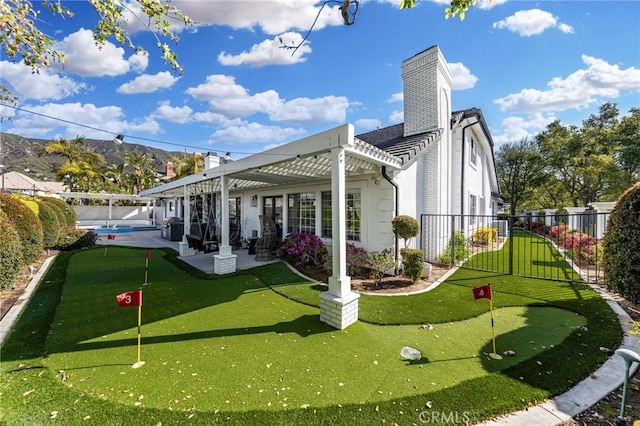 rear view of property with a mountain view, a chimney, a patio, and fence