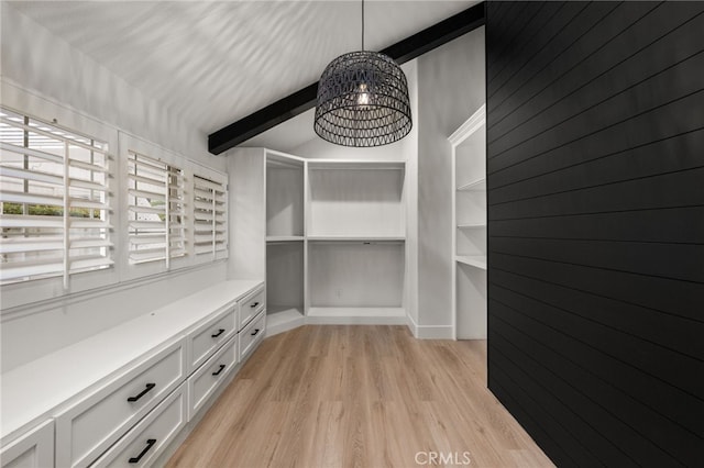 walk in closet with lofted ceiling with beams, a notable chandelier, and light wood-style flooring