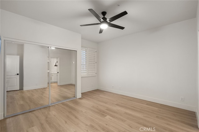 unfurnished bedroom featuring a closet, light wood-style flooring, and baseboards