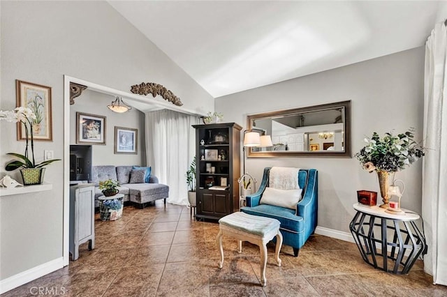 sitting room featuring baseboards, lofted ceiling, and tile patterned flooring