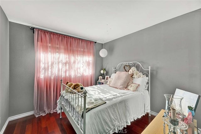 bedroom featuring baseboards and wood finished floors