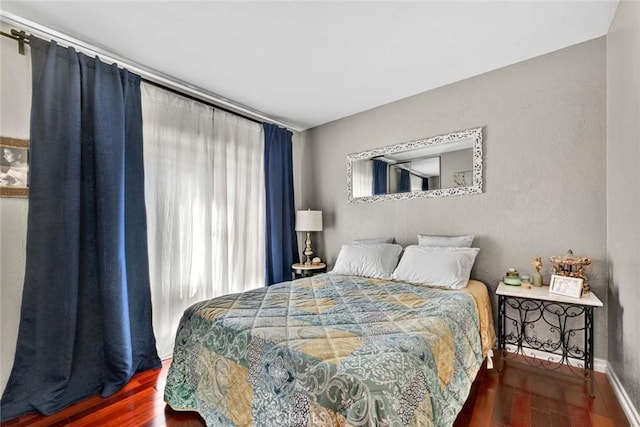 bedroom featuring baseboards and wood finished floors