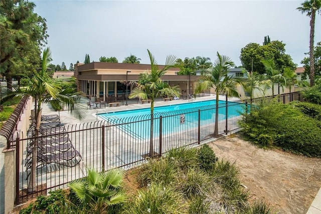 community pool with a patio and fence