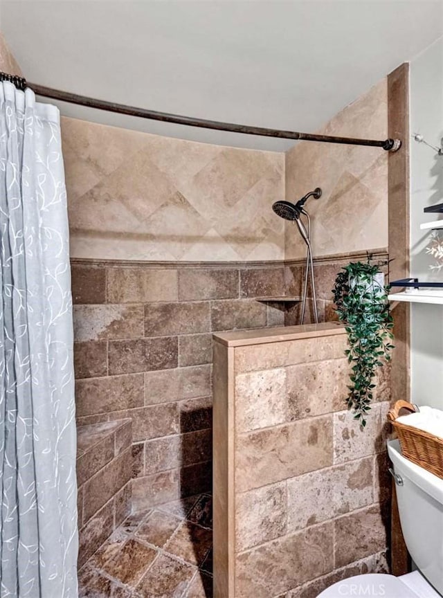 bathroom with toilet and tiled shower