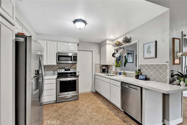 kitchen with white cabinetry, light countertops, appliances with stainless steel finishes, and a sink