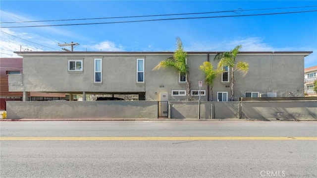 back of property featuring a fenced front yard and stucco siding