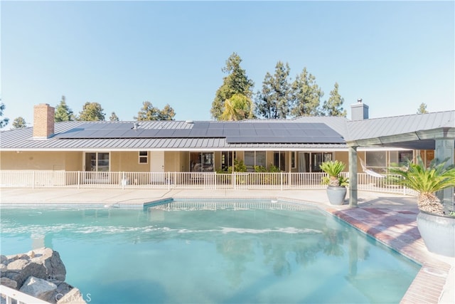 pool with a patio and fence