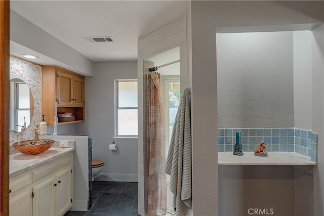 full bath featuring visible vents, toilet, a shower with shower curtain, baseboards, and vanity