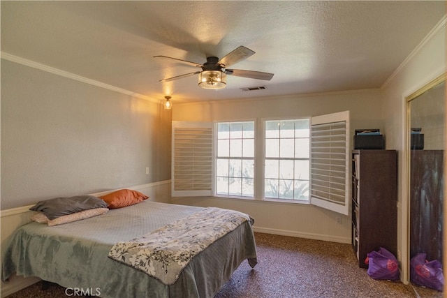 bedroom with carpet, baseboards, visible vents, ceiling fan, and crown molding