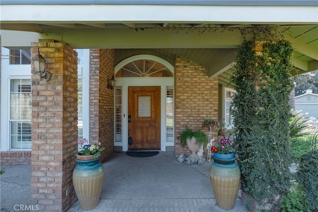 entrance to property featuring brick siding