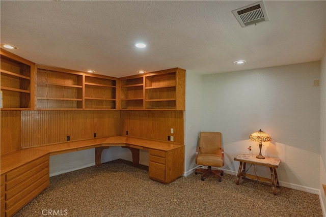 carpeted home office with recessed lighting, visible vents, built in desk, and a textured ceiling