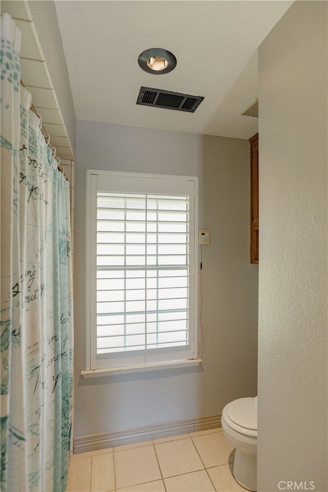 bathroom featuring tile patterned floors, visible vents, toilet, and baseboards