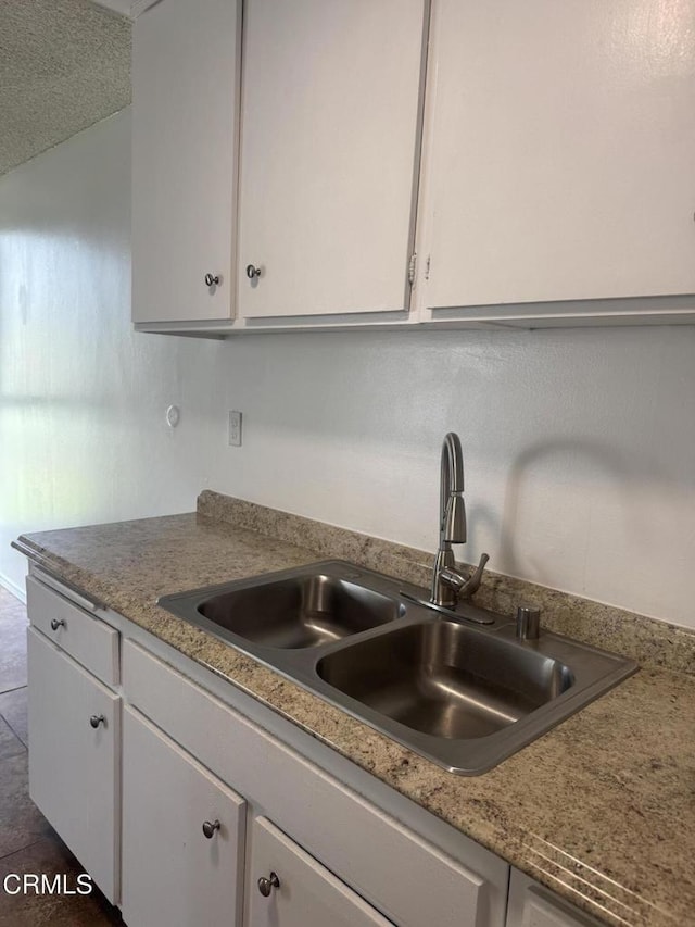 kitchen featuring a sink and white cabinets