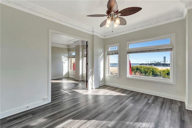 spare room featuring baseboards, dark wood-type flooring, ornamental molding, and a ceiling fan