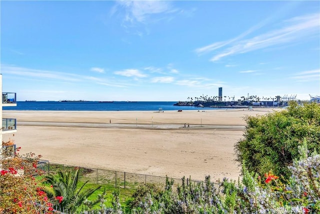 view of water feature with fence and a beach view