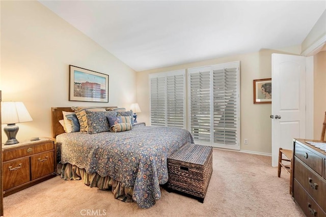 bedroom featuring baseboards, lofted ceiling, and light colored carpet