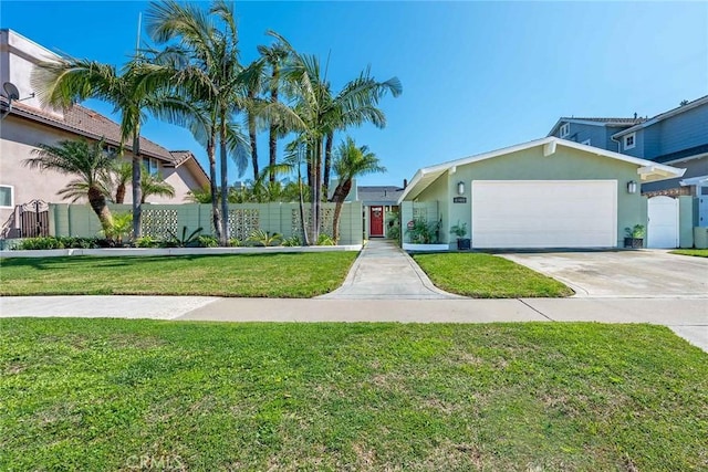 view of front of property with a front lawn, fence, stucco siding, driveway, and an attached garage