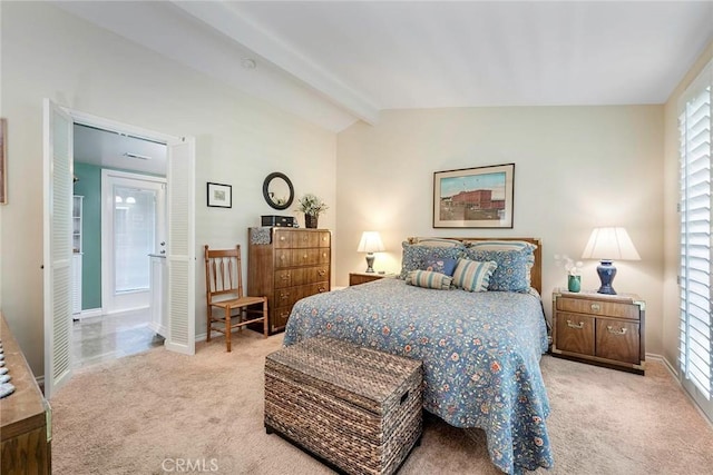 carpeted bedroom featuring ensuite bath, lofted ceiling with beams, and baseboards