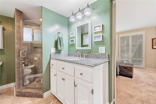 full bathroom with a stall shower, vanity, and baseboards