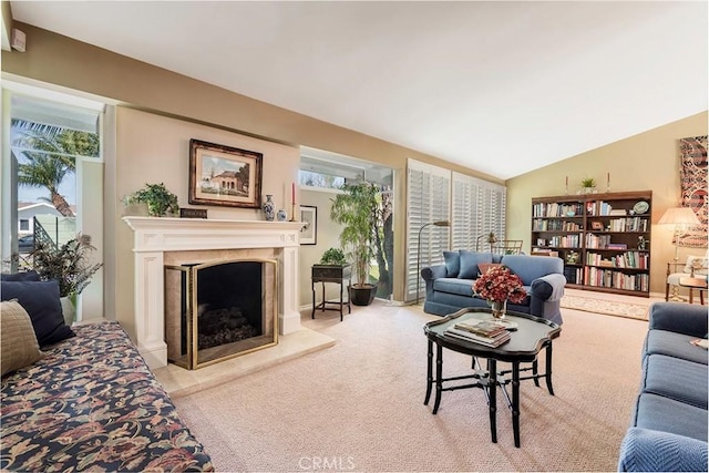 carpeted living room with a high end fireplace and lofted ceiling