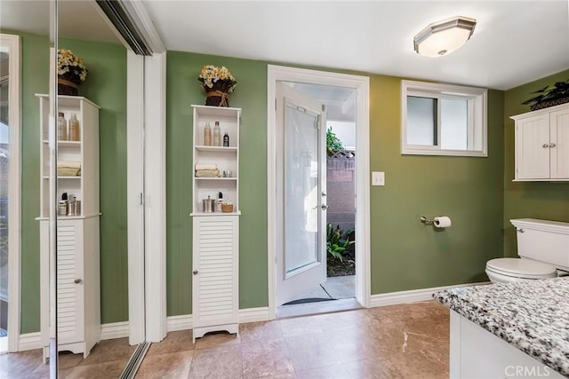 bathroom featuring vanity, toilet, and baseboards