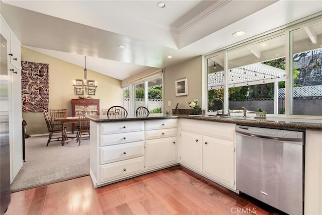 kitchen with light wood finished floors, a peninsula, a sink, white cabinets, and stainless steel dishwasher