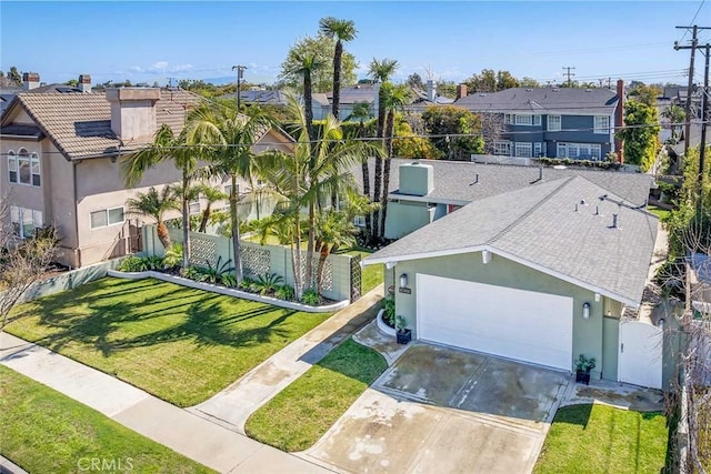 view of front facade featuring fence, driveway, an attached garage, stucco siding, and a front lawn