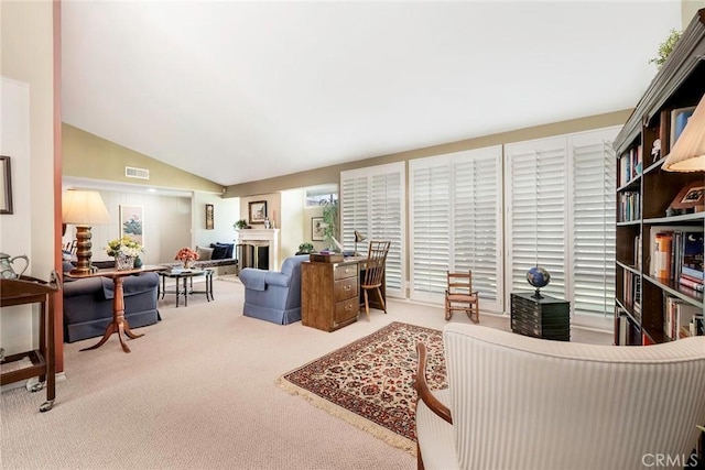 living area featuring carpet flooring, a fireplace, visible vents, and vaulted ceiling