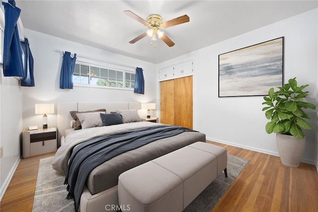 bedroom featuring wood finished floors, baseboards, a closet, and ceiling fan