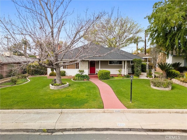 ranch-style house with a front yard and a shingled roof