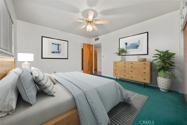 carpeted bedroom featuring visible vents and a ceiling fan