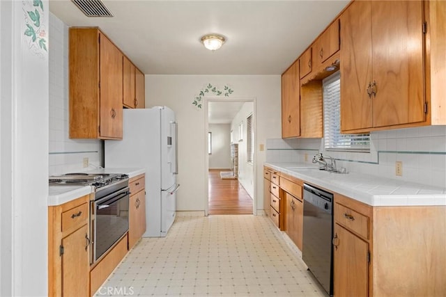 kitchen featuring visible vents, light floors, dishwasher, electric range, and a sink