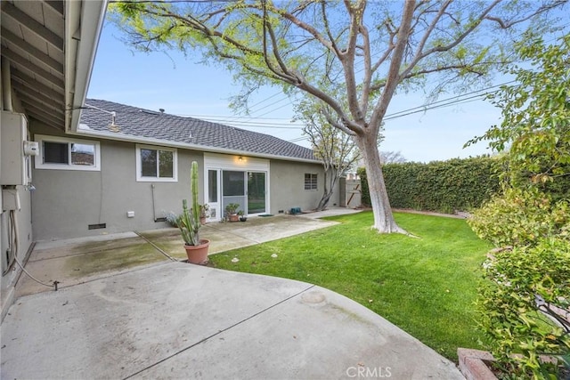 rear view of house featuring a patio area, stucco siding, a shingled roof, and a yard