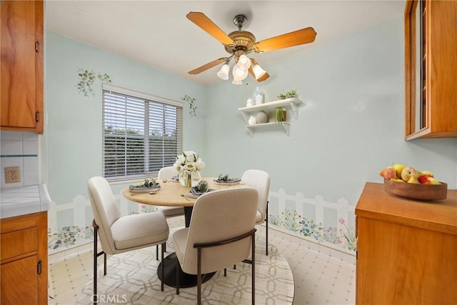 dining area featuring a ceiling fan and light floors